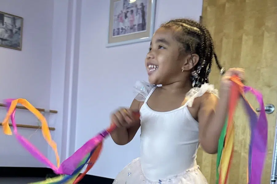 Joyful Ballet Student Dancing with Ribbons