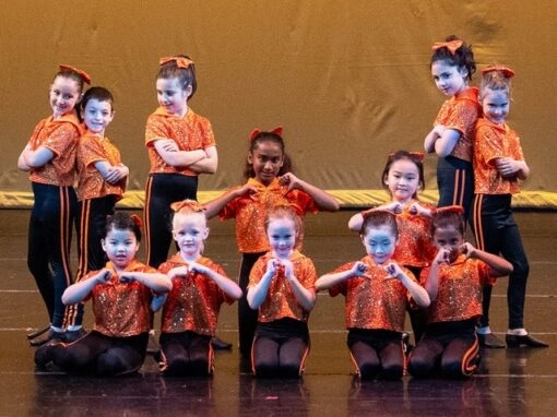 Children’s Dance Performance in Orange Costumes