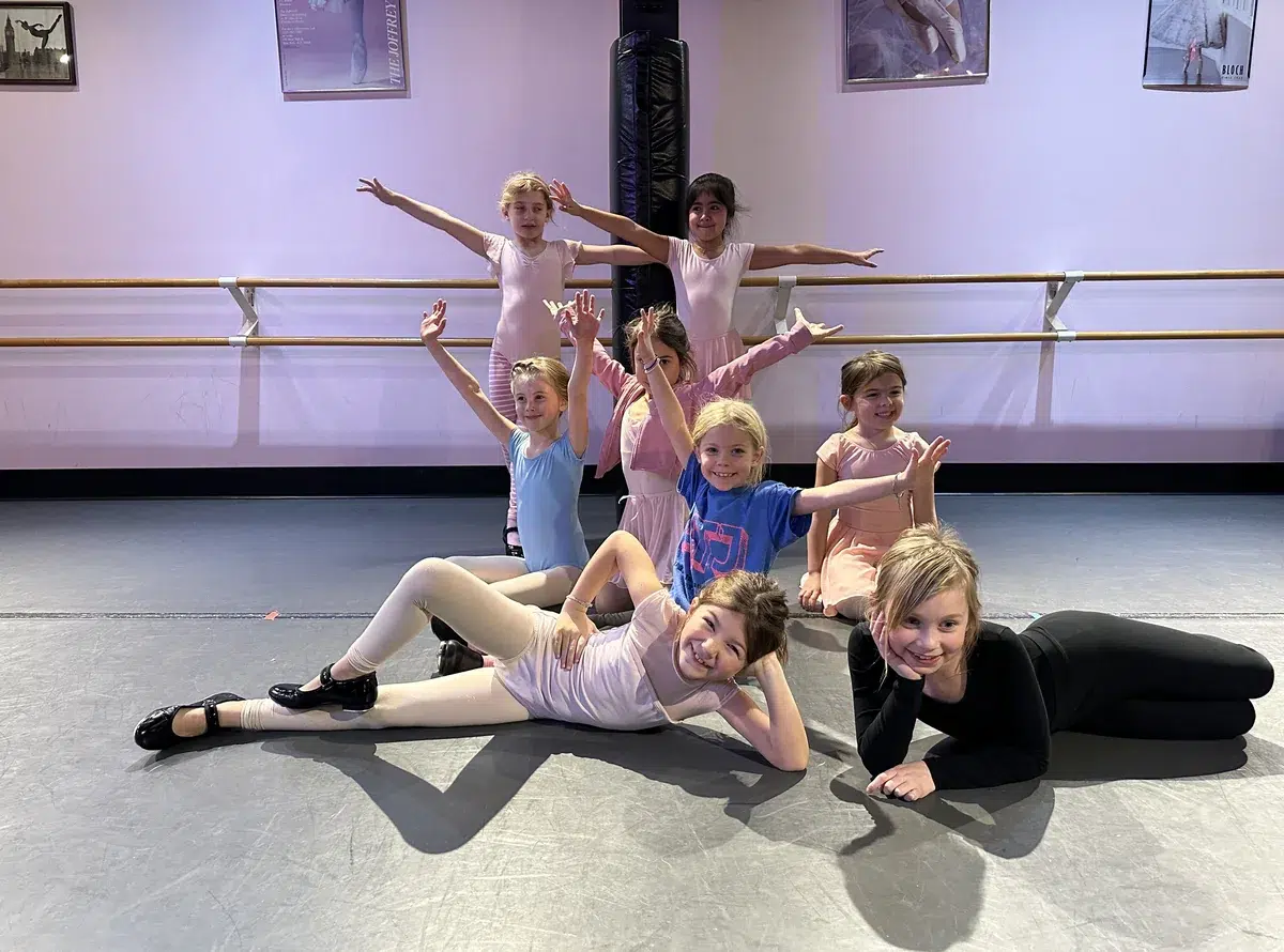 Young dancers in ballet and tap shoes pose together during a Ballet/Tap Combo class