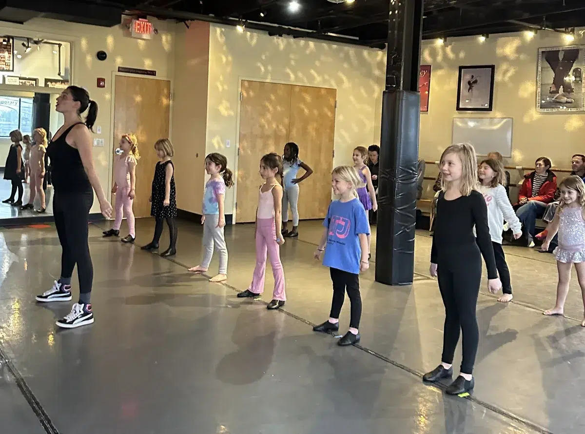 Elementary-age dancers line up with their teacher during a Hip Hop class for ages 7 to 11