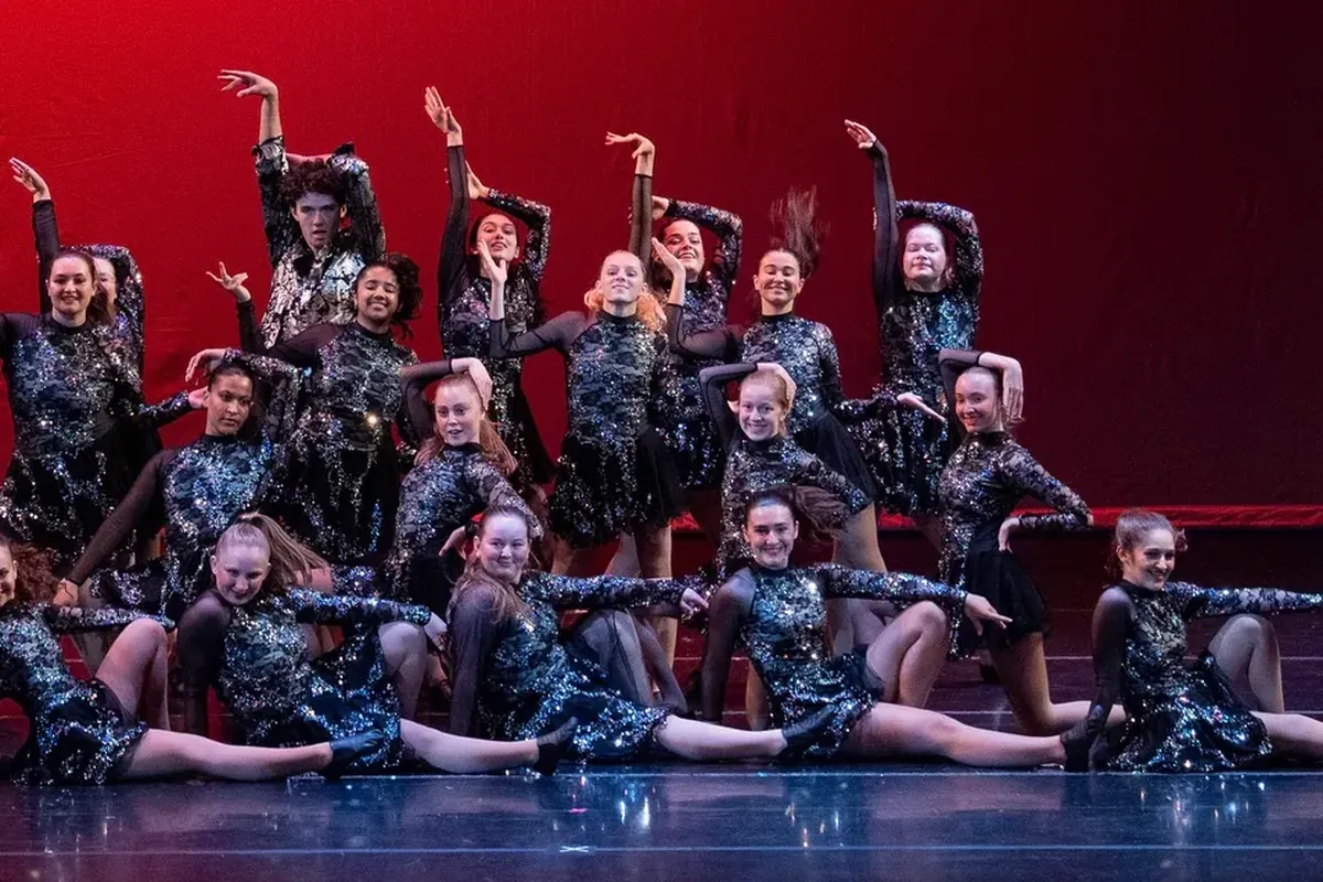 All That Jazz senior jazz team posing on stage in sequined black costumes