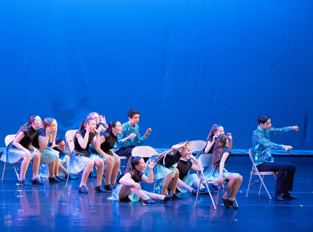 Musical Theater dancers perform a chair number in blue sequin costumes